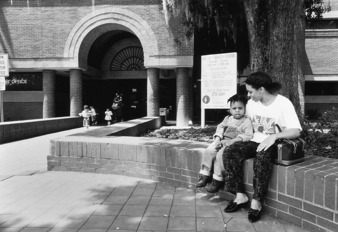 Woman and child sitting outside of health center