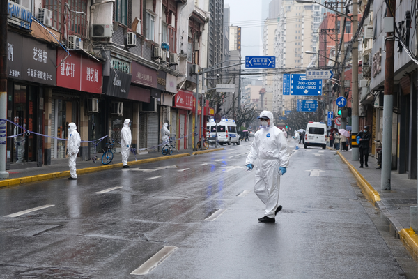 Worker wearing white Hazmat suits stand on the streets of Shanghai during a lockdown