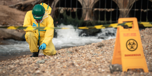 Environmental Worker Inspecting Industrial Hazard Zone During Wastewater Pollution Monitoring