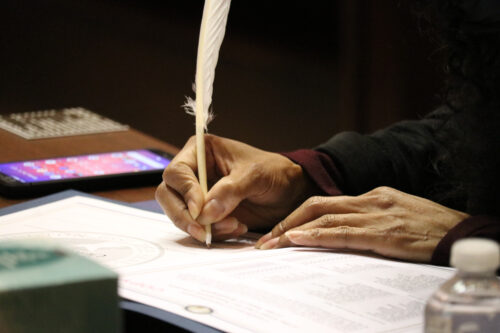 A presidential electoral in Washington State ceremonially signs an electoral college ballot