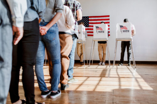 People waiting to vote in line at voting booths.