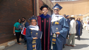 Board with two graduating students from his class at Howard University in 2026. 