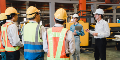 Workers surrounded in circle being informed by staff