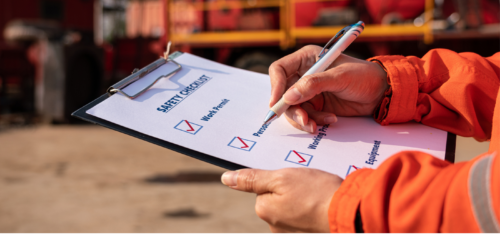 Employee writing on safety checklist