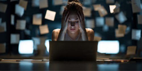 Woman looking at laptop overwhelmed