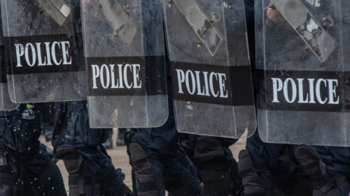 An image of 4 police officer shields.
