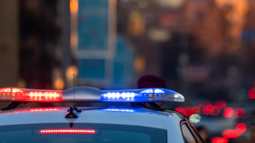 A photo of the top of a police car in evening traffic.