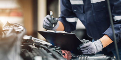 Mechanic reviewing hood of a car
